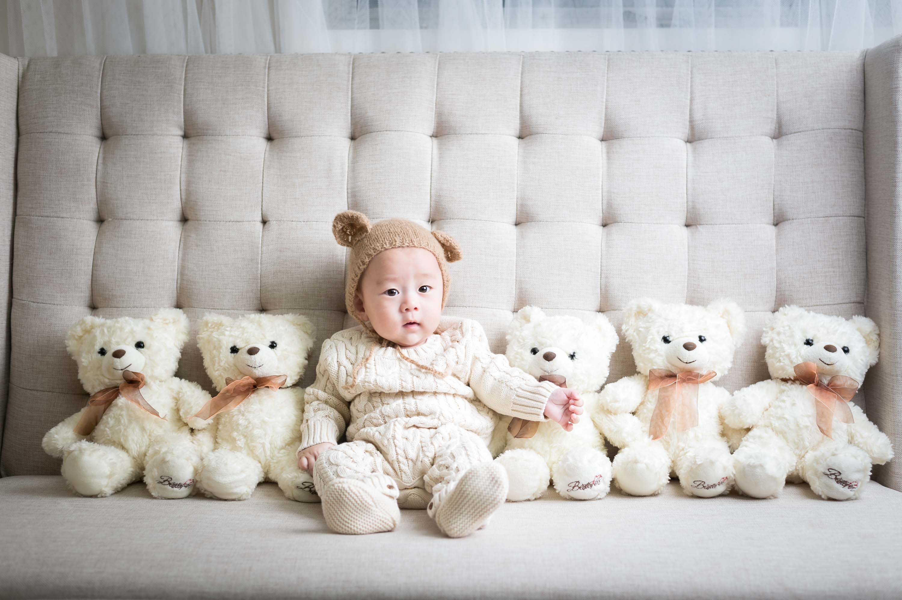 Young child seated with teddy bears