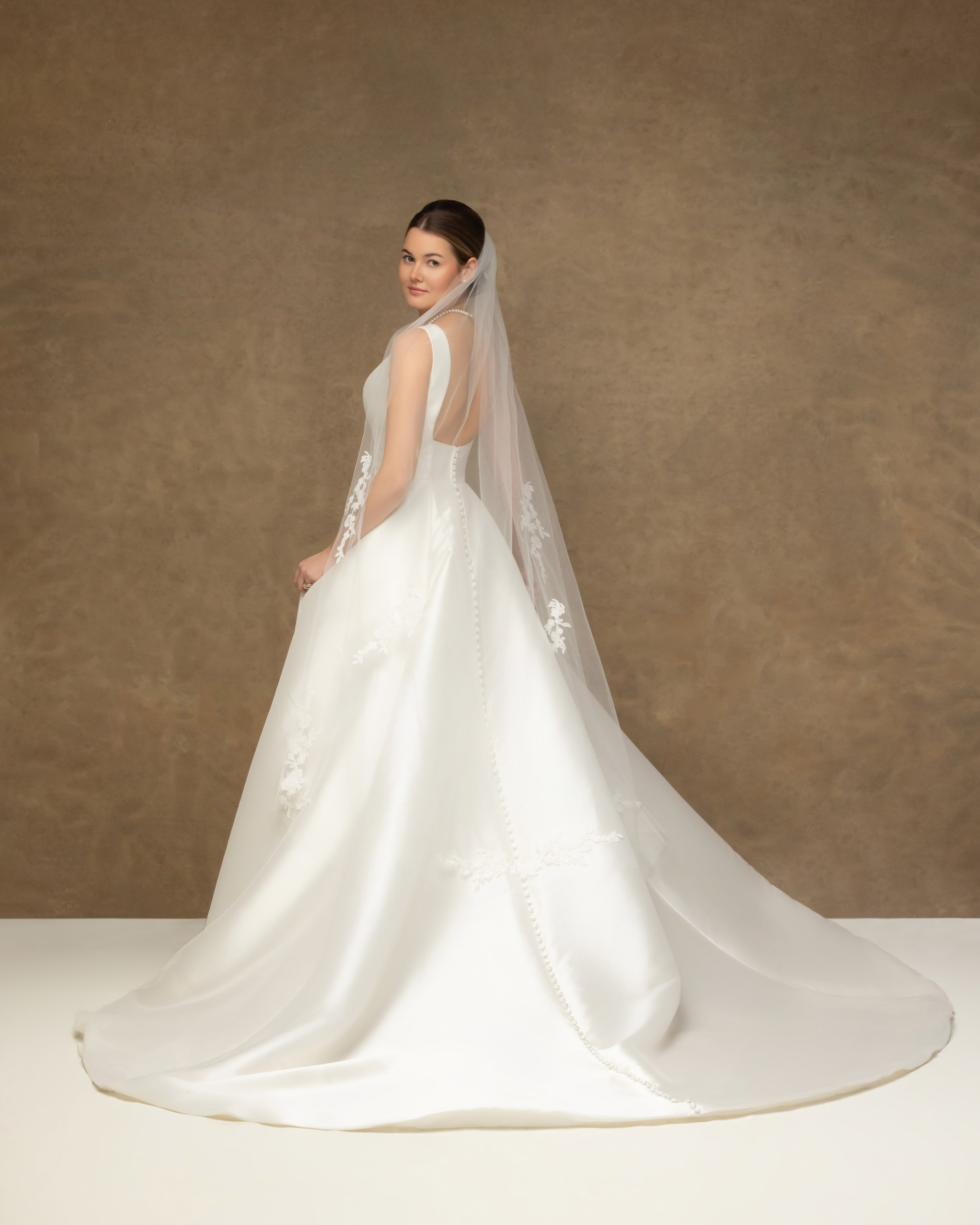 Bride in her wedding gown and veil photographed alone in the studio after her wedding