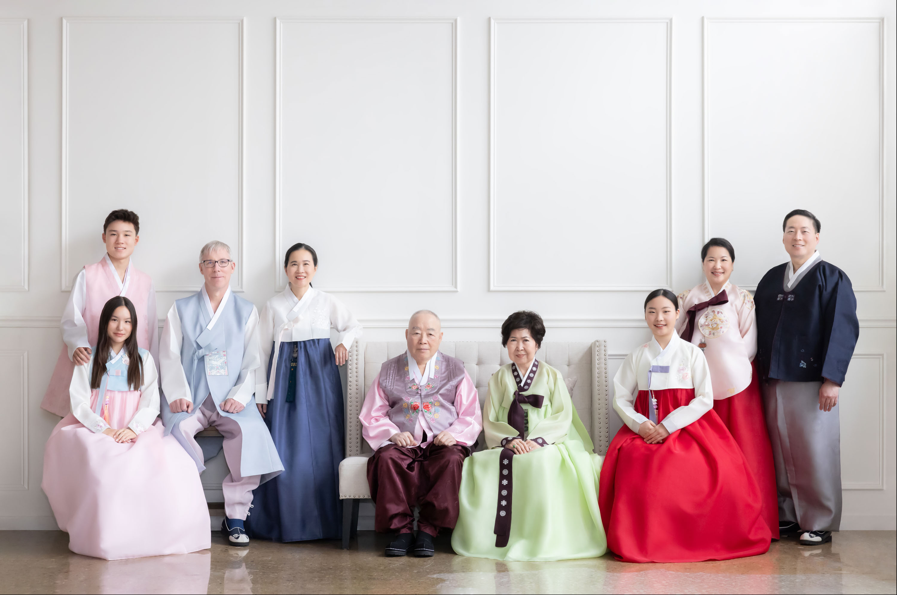 Three generations of a family wearing hanbok in a studio portrait