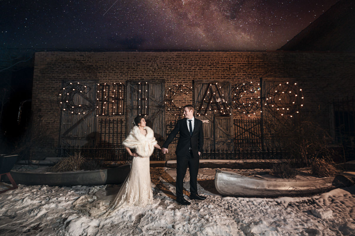 Couple in wedding attire outdoors on a snowy Chicago evening